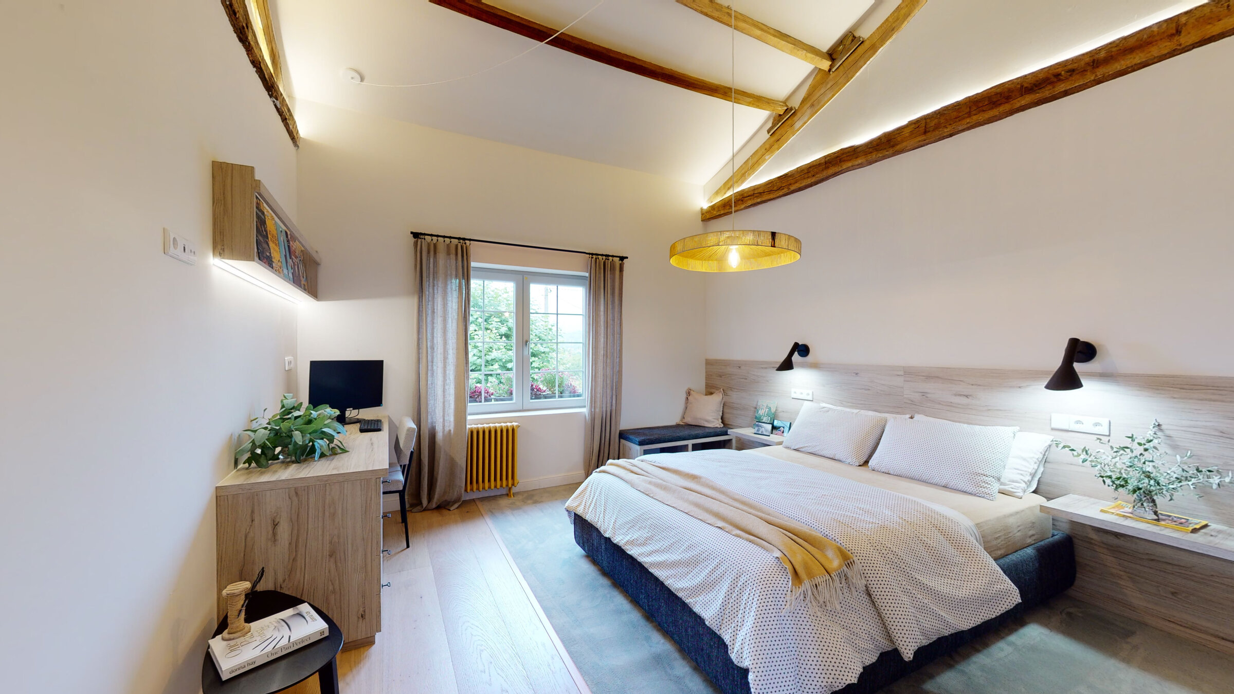 Bedroom with writing desk beneath exposed beams
